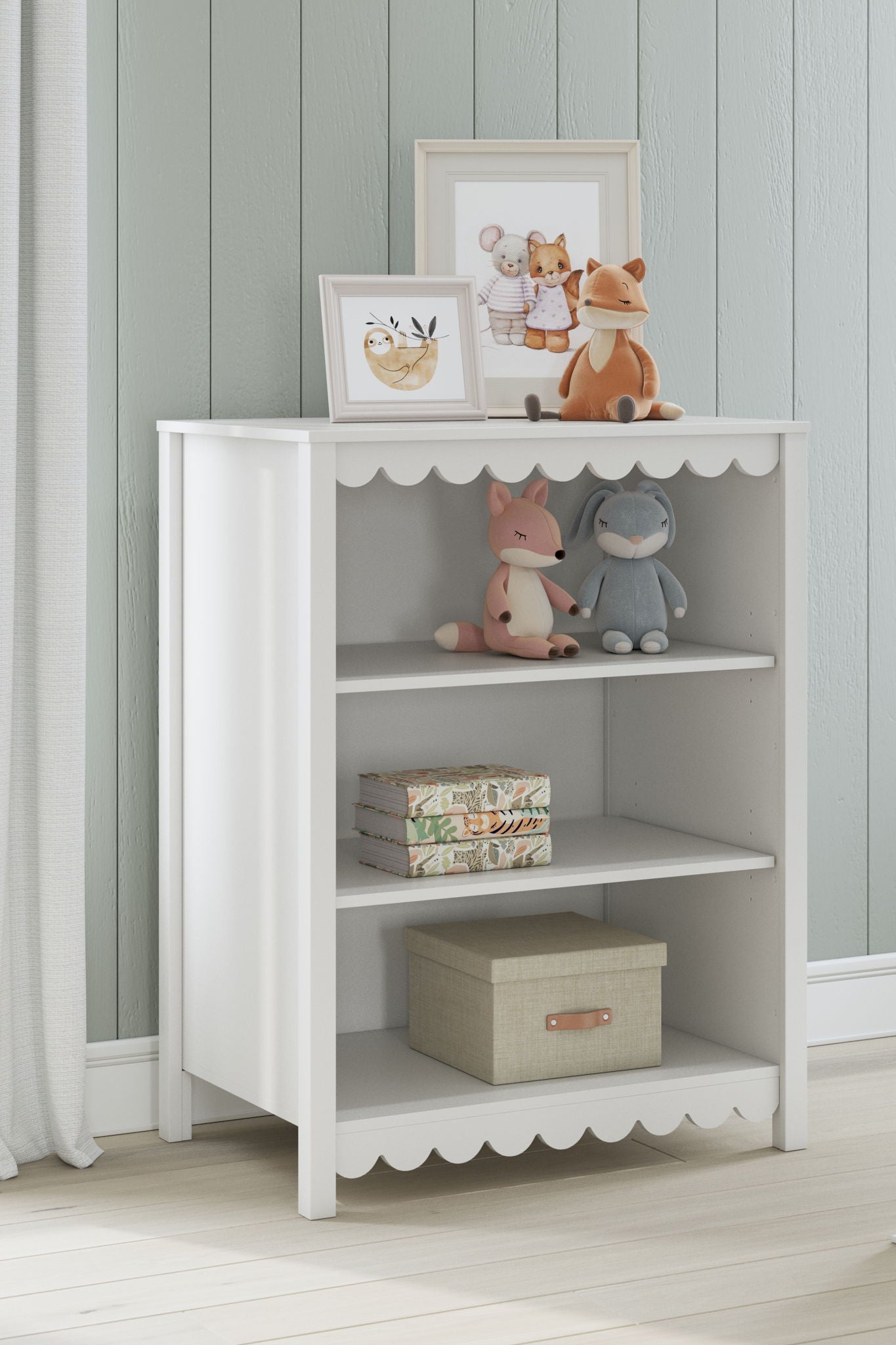 White bookcase with scalloped trim and open cubbies displaying books and decor