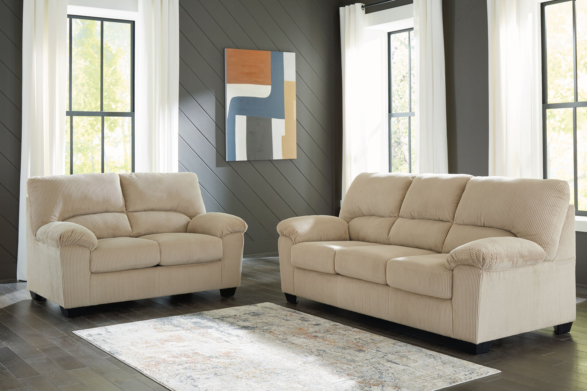 Beige upholstered loveseat and sofa with tufted backs and padded arms.