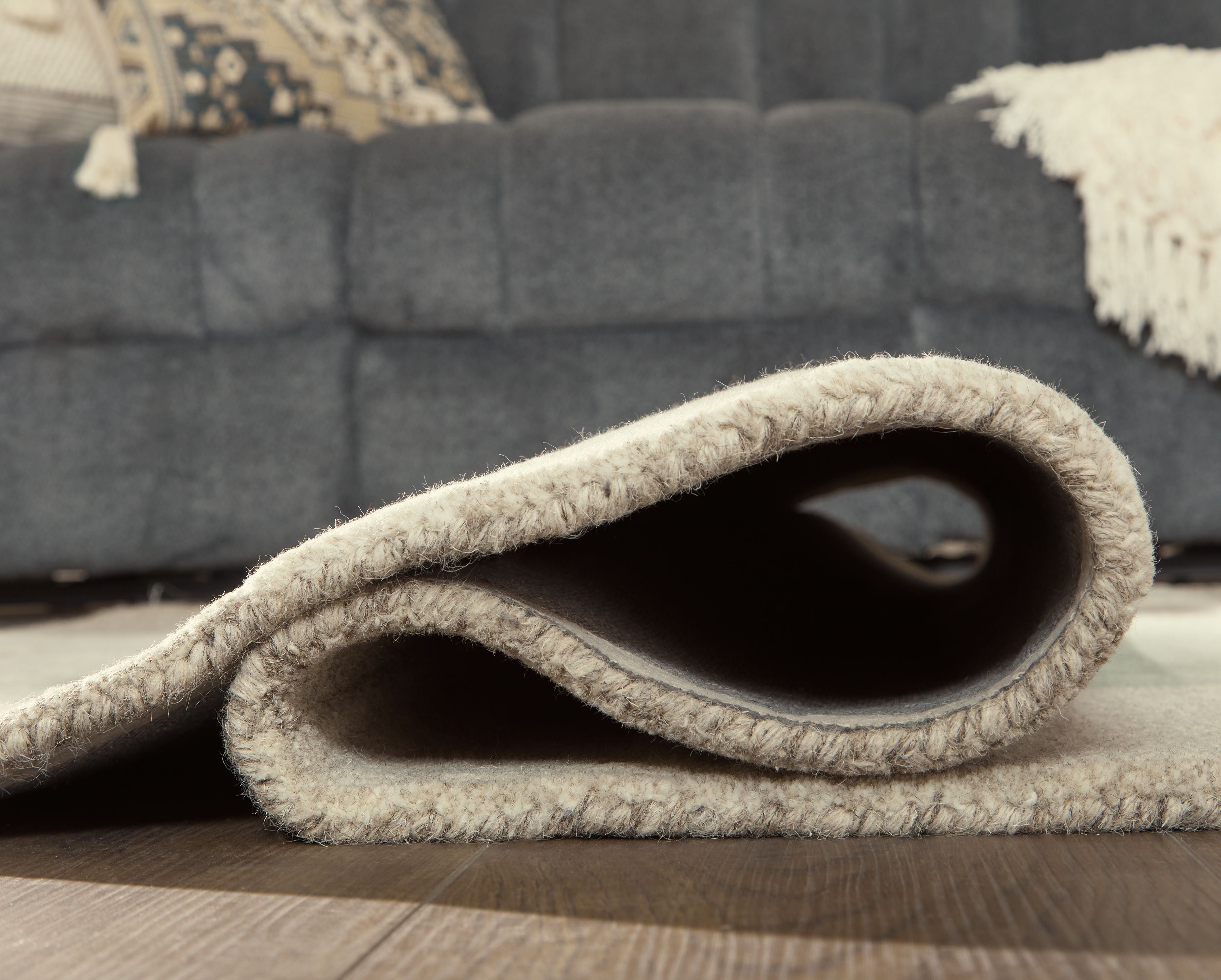 Ivory rug corner with curled edge and soft textured pile