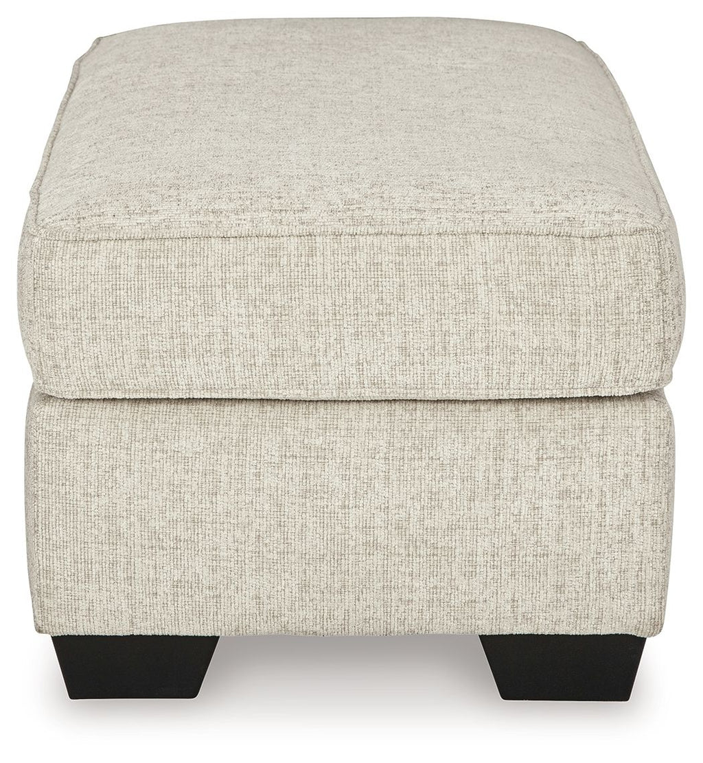 Light beige fabric ottoman with rounded top and dark legs