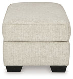 Light beige fabric ottoman with rounded top and dark legs