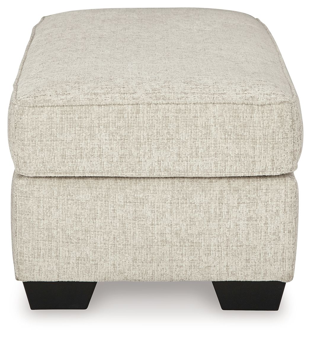 Light beige fabric ottoman with rounded top and dark legs