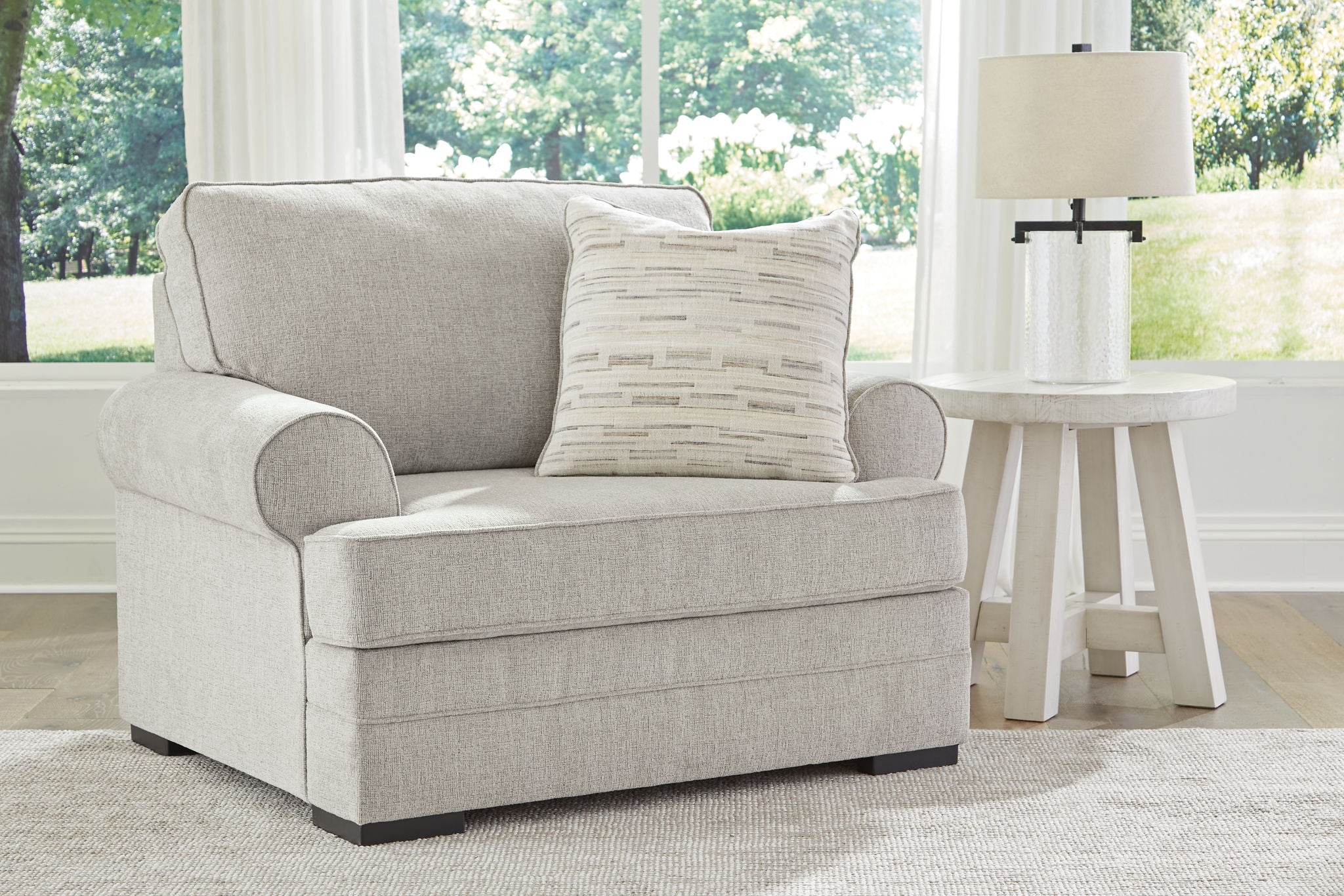 Gray upholstered armchair with lumbar pillow and coordinated throw cushions