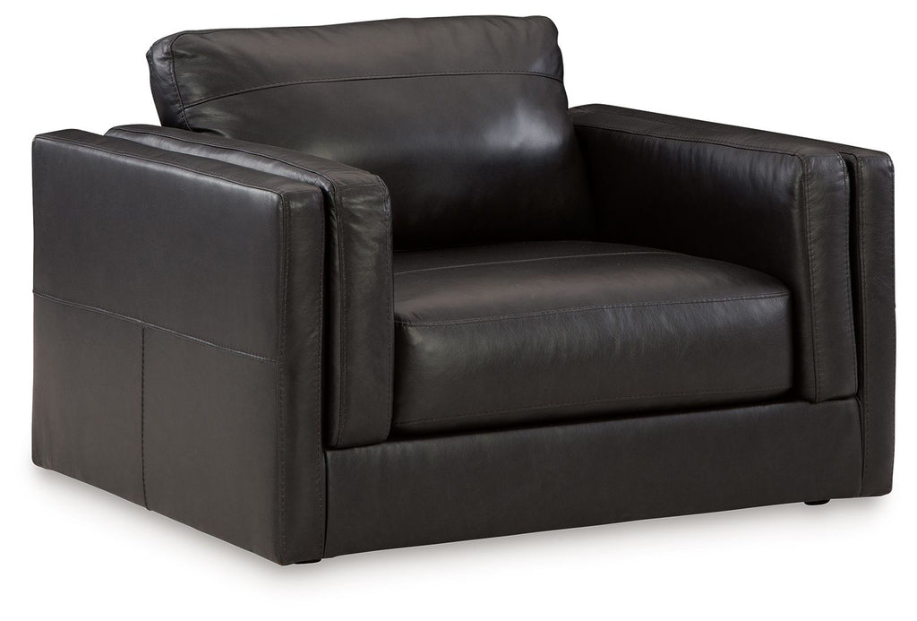 Amiata onyx chair and a half with dark leather upholstery and wide armrests.