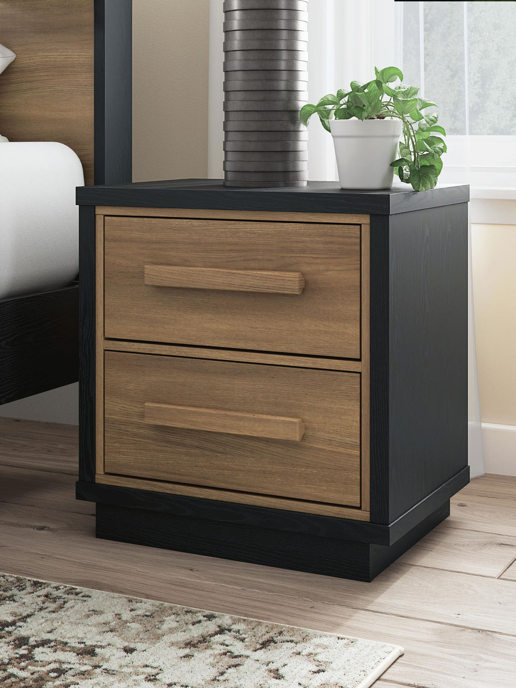 Two-drawer nightstand in black with light wood fronts and bar pulls, compact size
