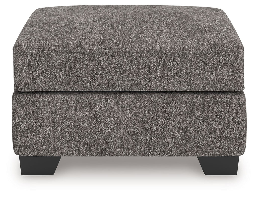 Dark gray upholstered ottoman with upholstered lid and four tapered black feet