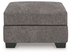 Dark gray upholstered ottoman with upholstered lid and four tapered black feet