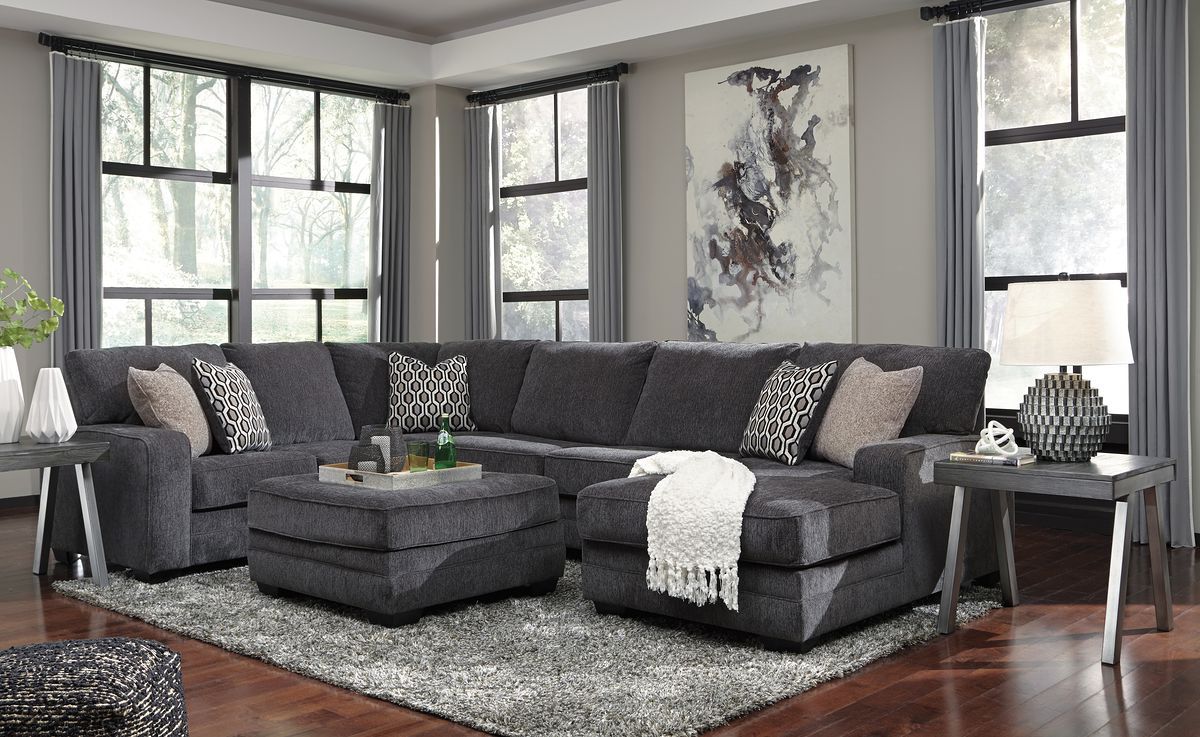 Dark gray sectional sofa with chaise and ottoman, patterned decorative cushions