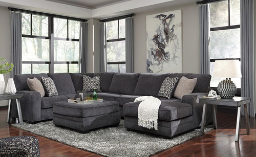Dark gray sectional sofa with chaise and ottoman, patterned decorative cushions