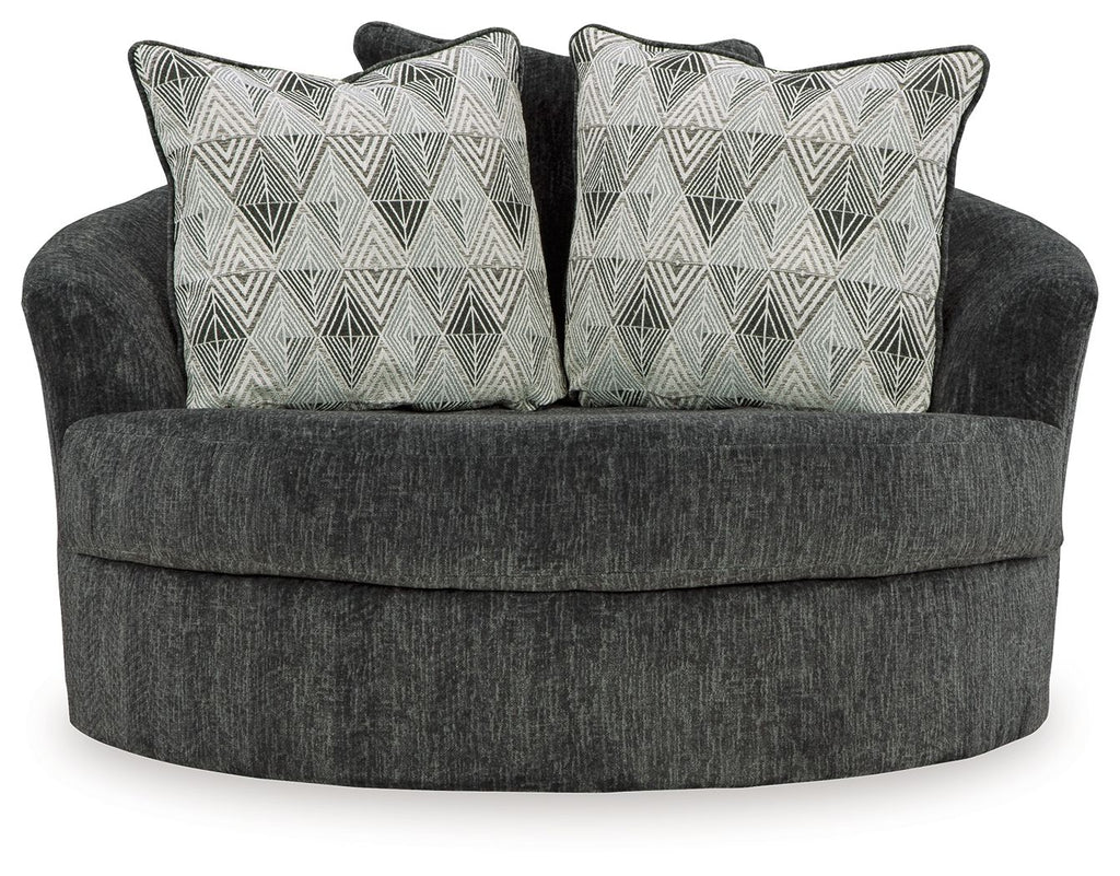 Oversized swivel accent chair in dark gray with two geometric patterned throw pillows