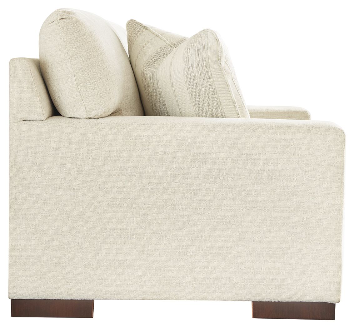 Cream loveseat side view with two back pillows and dark wood block feet