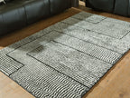Black-and-white striped geometric rug with framed border lines.