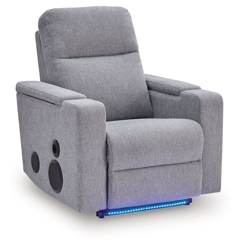 Pewter gray power recliner with speaker cutouts on armrests and padded headrest