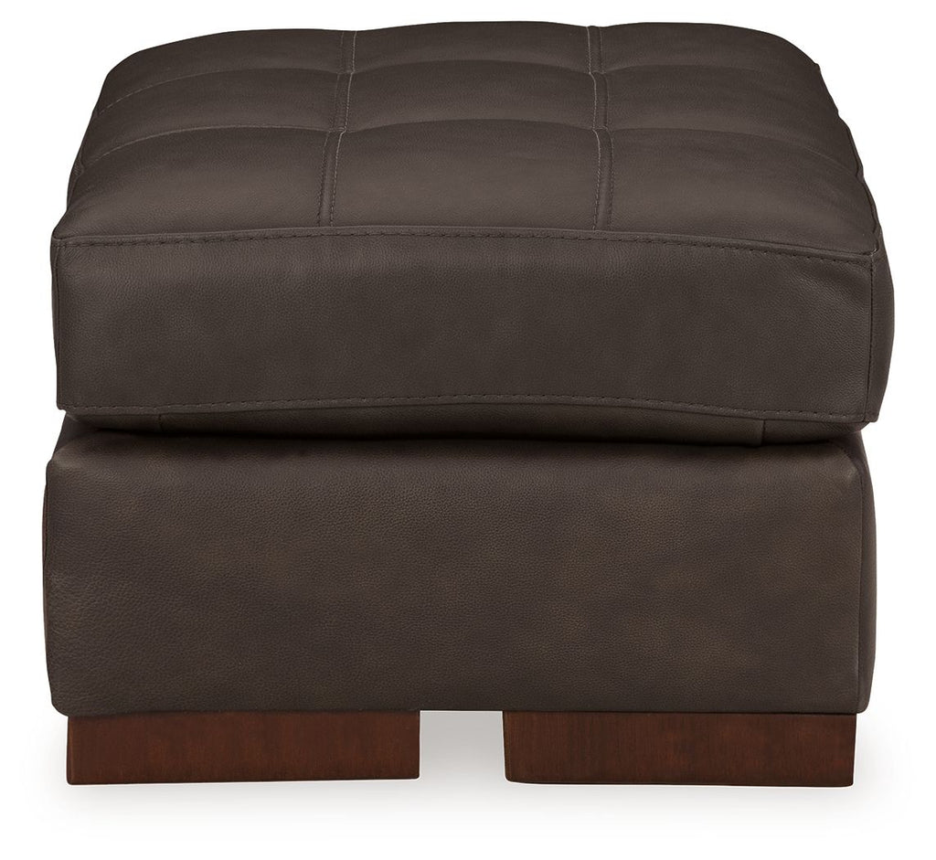 Dark brown tufted upholstered ottoman, front view with thick cushioned seat and feet