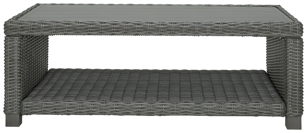 Gray rectangular cocktail table with woven top frame and cushioned base