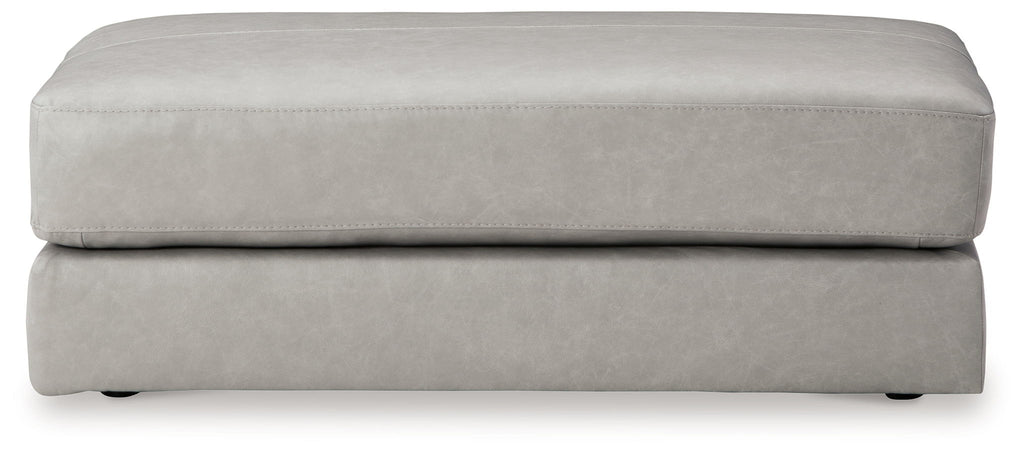 Light gray oversized ottoman with stitched top edge and low skirt