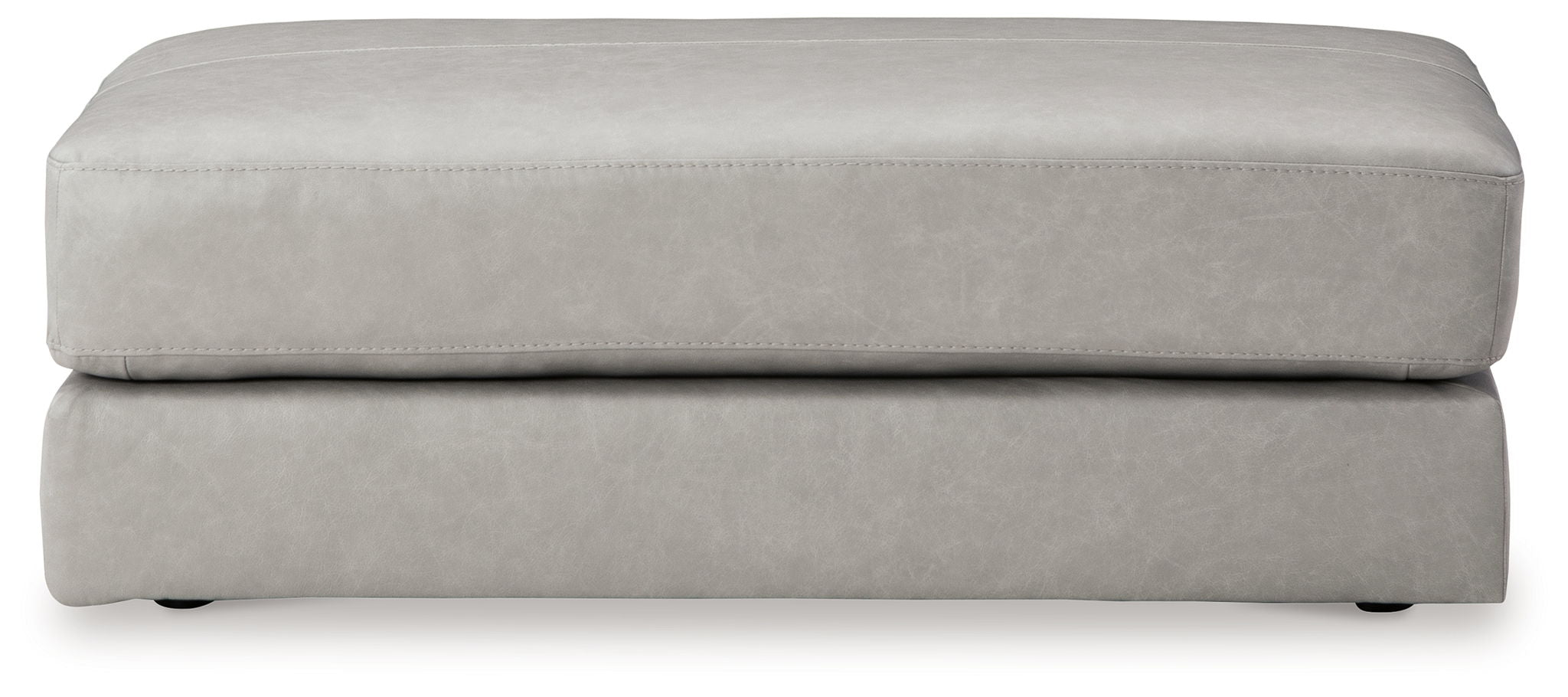 Light gray oversized ottoman with stitched top edge and low skirt
