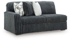 Ribbed corduroy sofa, gunmetal-gray upholstery, two throw pillows (patterned and solid)