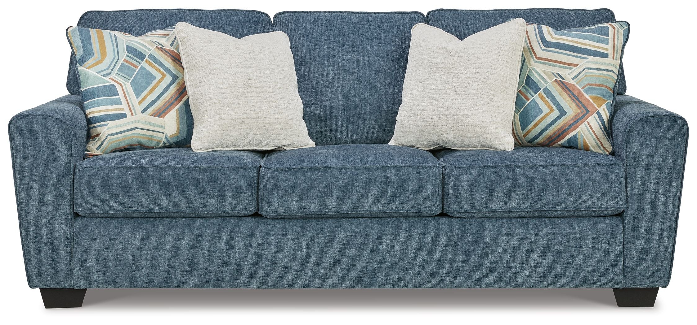 Blue upholstered sofa with three seat cushions and four pillows, two patterned accent throws