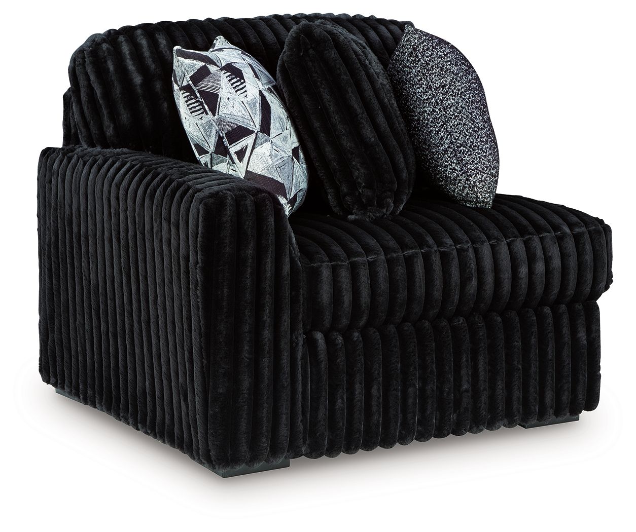 Black corduroy corner chair with rounded arms, deep seat, and patterned throw cushion