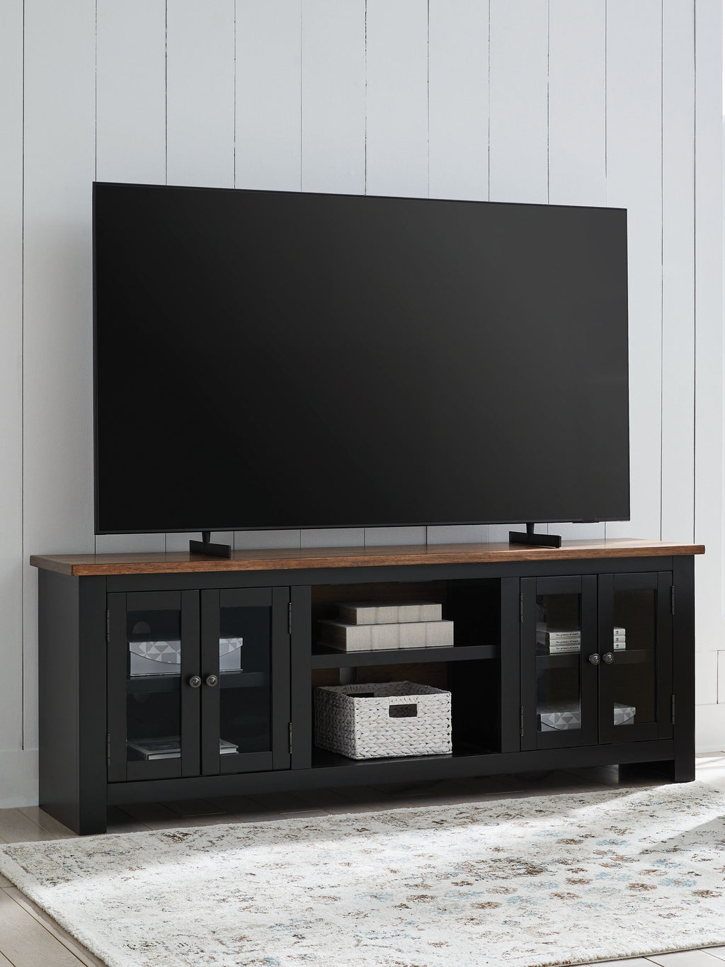Brown-and-black TV stand with fireplace, open storage shelves and glass cabinet doors