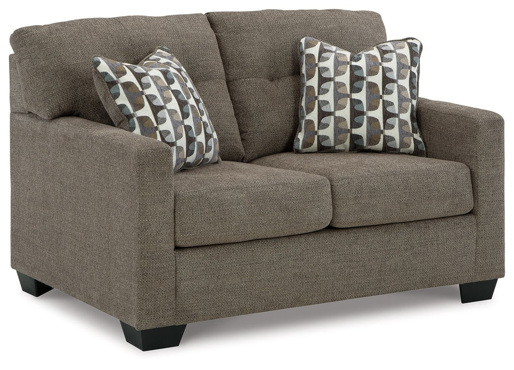 Loveseat with dark brown upholstery and two patterned throw pillows
