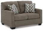 Loveseat with dark brown upholstery and two patterned throw pillows