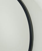 Brocky black round accent mirror frame edge close-up