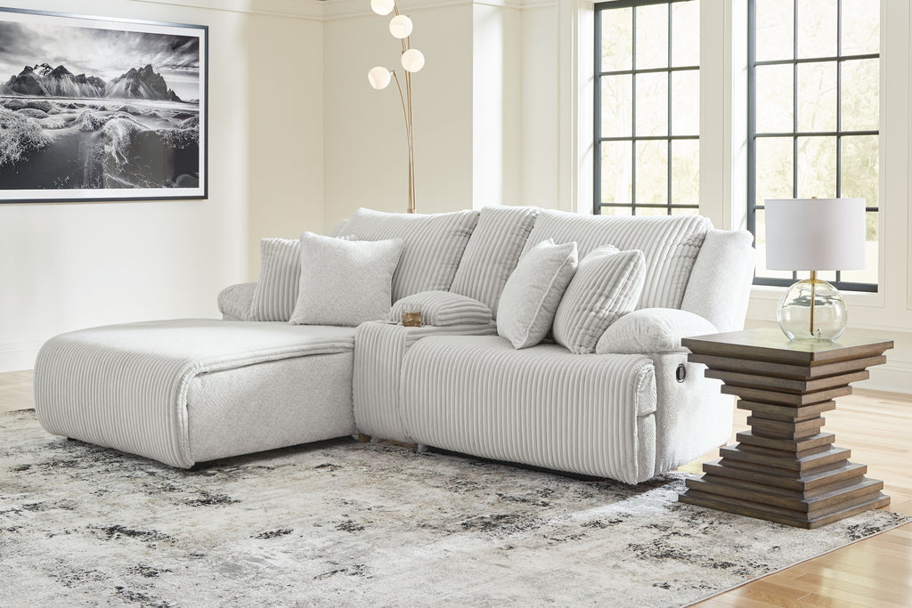 Reclining sectional sofa in light fabric with multiple striped cushions and back pillows