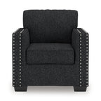 Dark charcoal upholstered armchair with square arms, seat cushion, and silver nailhead trim.
