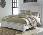 White panel bed with tall headboard, decorative bedding and pillows