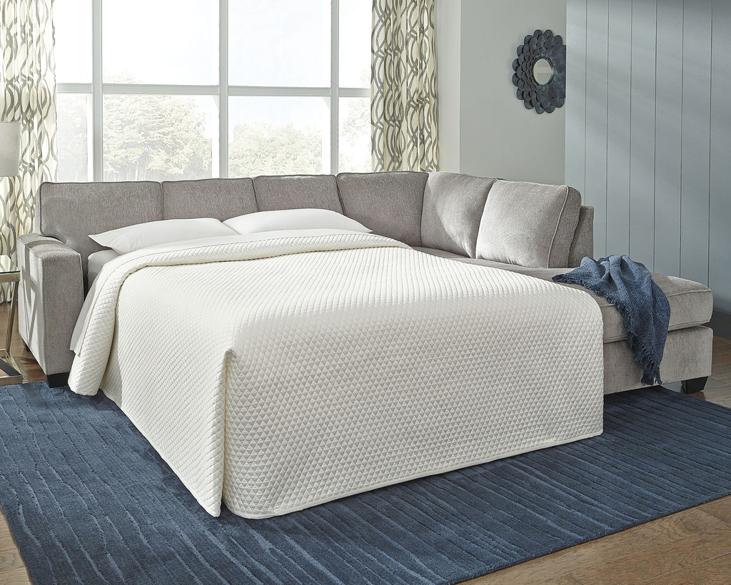 Light gray sectional sleeper sofa with chaise, open bed, and white fitted blanket