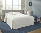 Light gray sectional sleeper sofa with chaise, open bed, and white fitted blanket