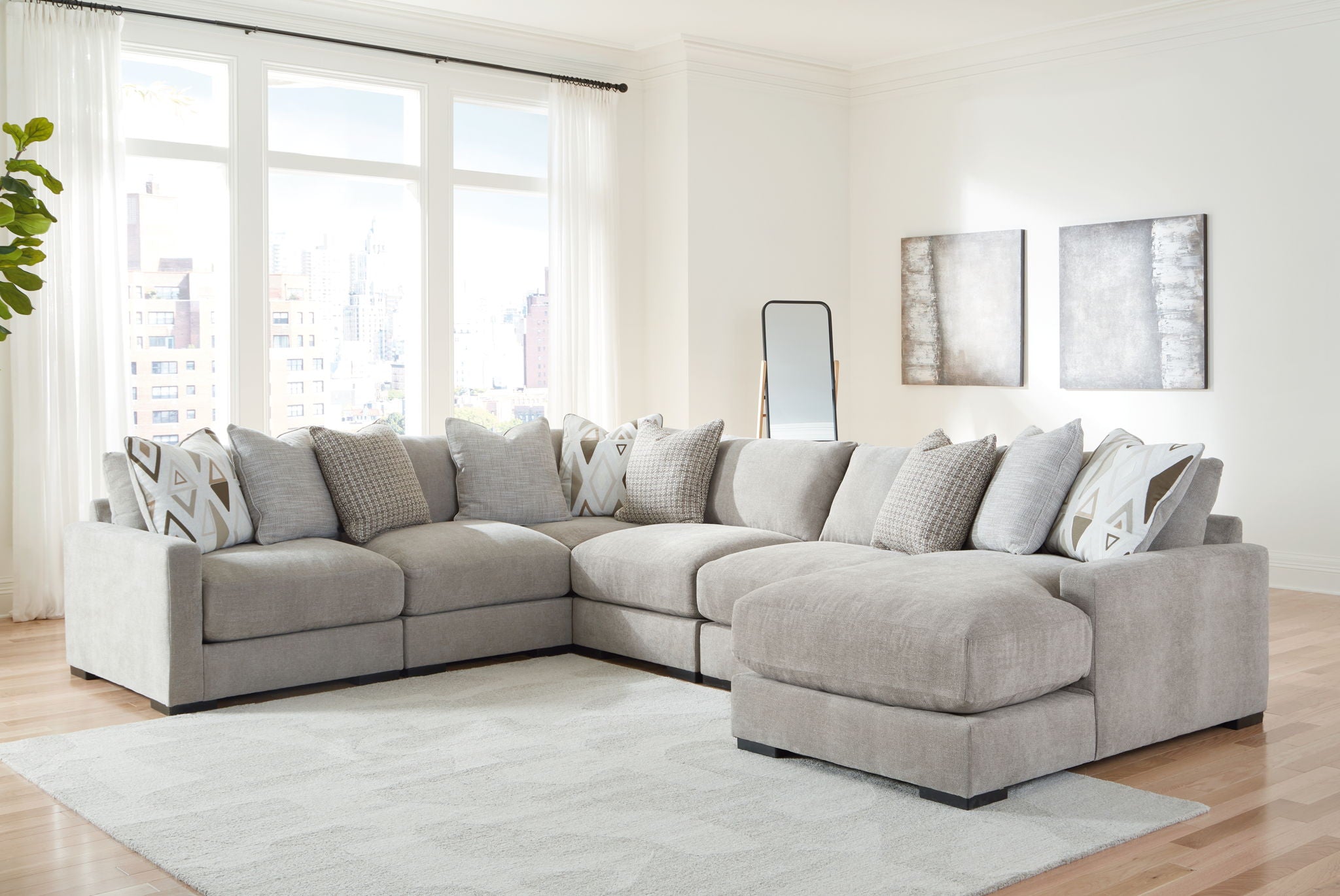 Gray sectional sofa with chaise corner and patterned throw pillows, includes matching ottoman