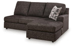 Dark charcoal sofa chaise with chaise ottoman, tufted seat, and patterned throw pillow