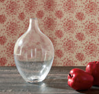 Speckled clear glass vase with narrow neck and rounded body, front view.