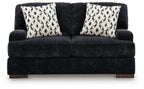 Dark charcoal loveseat with two black-and-white patterned throw pillows, wide seat