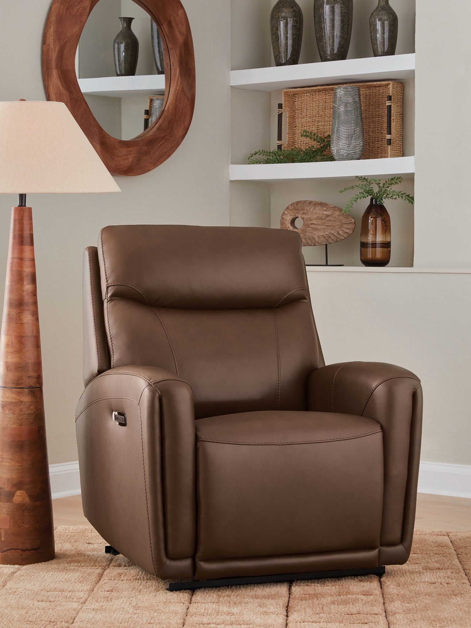 Brown leather-look recliner in upright position with padded headrest and arm storage