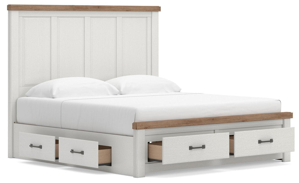 White panel storage bed with wood-trim top and three front pull-out drawers, angled view