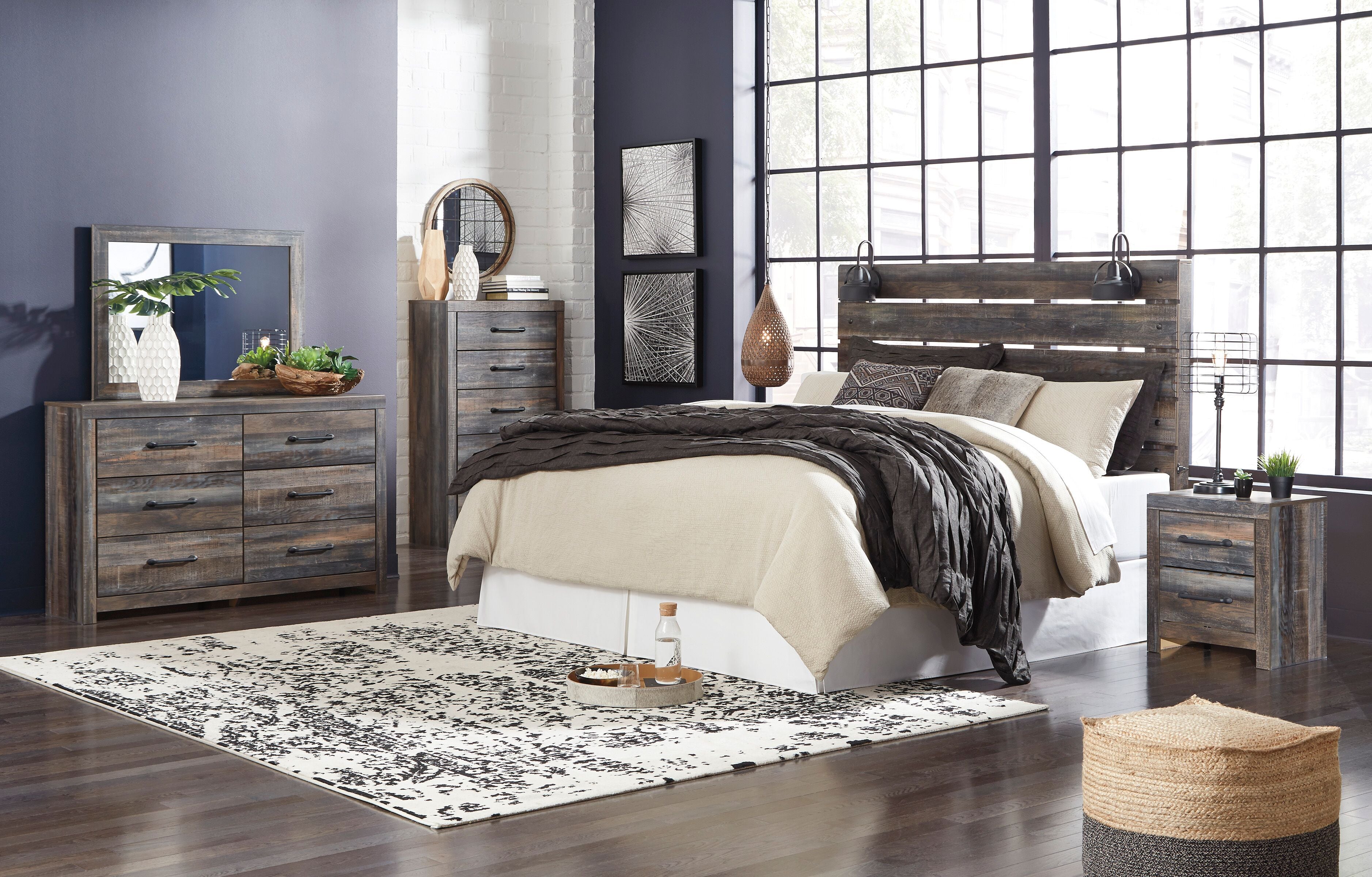 Bedroom set with dark gray panel bed, beige and charcoal bedding, plus matching dresser and nightstand