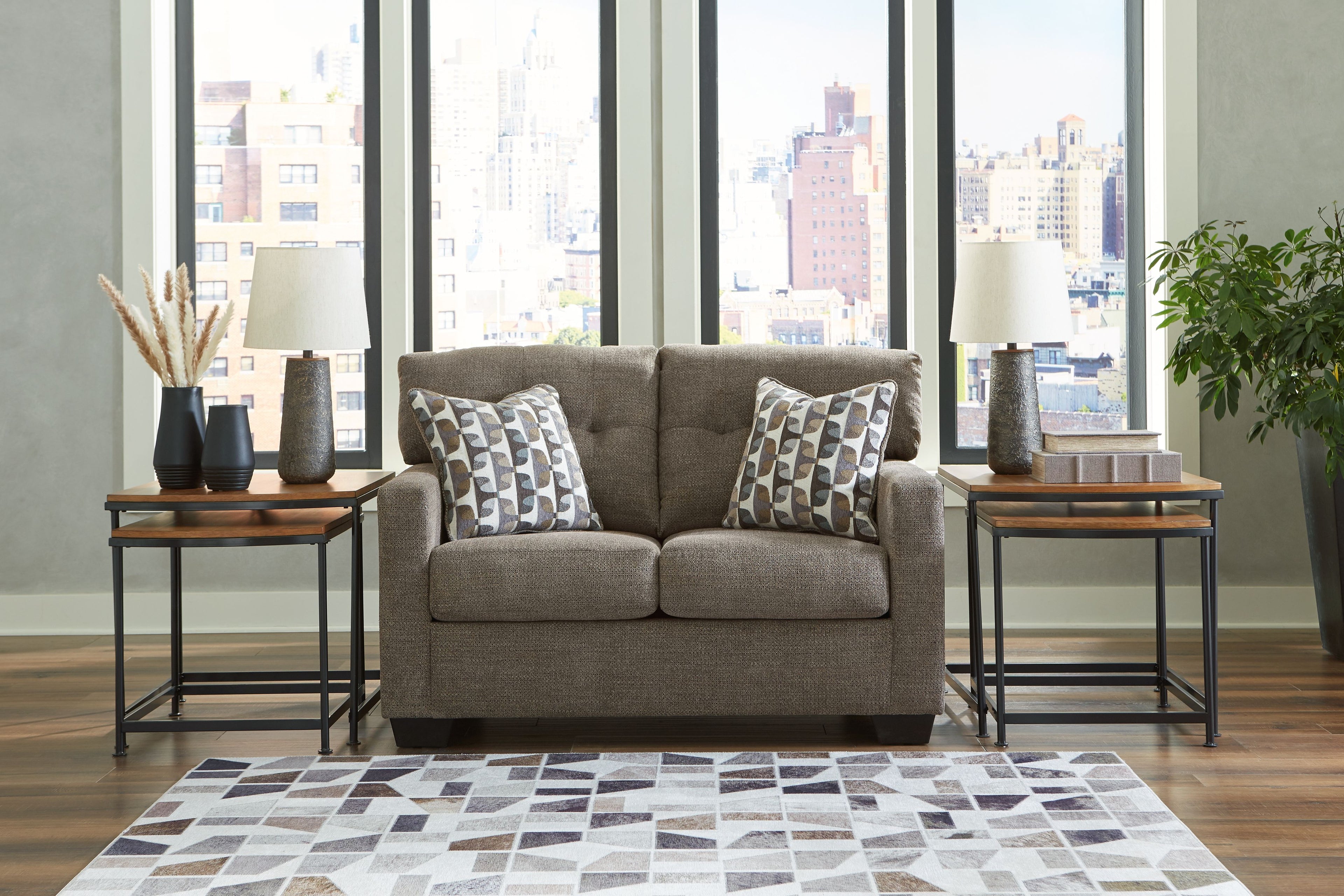 Dark brown loveseat with two patterned throw pillows centered on the sofa