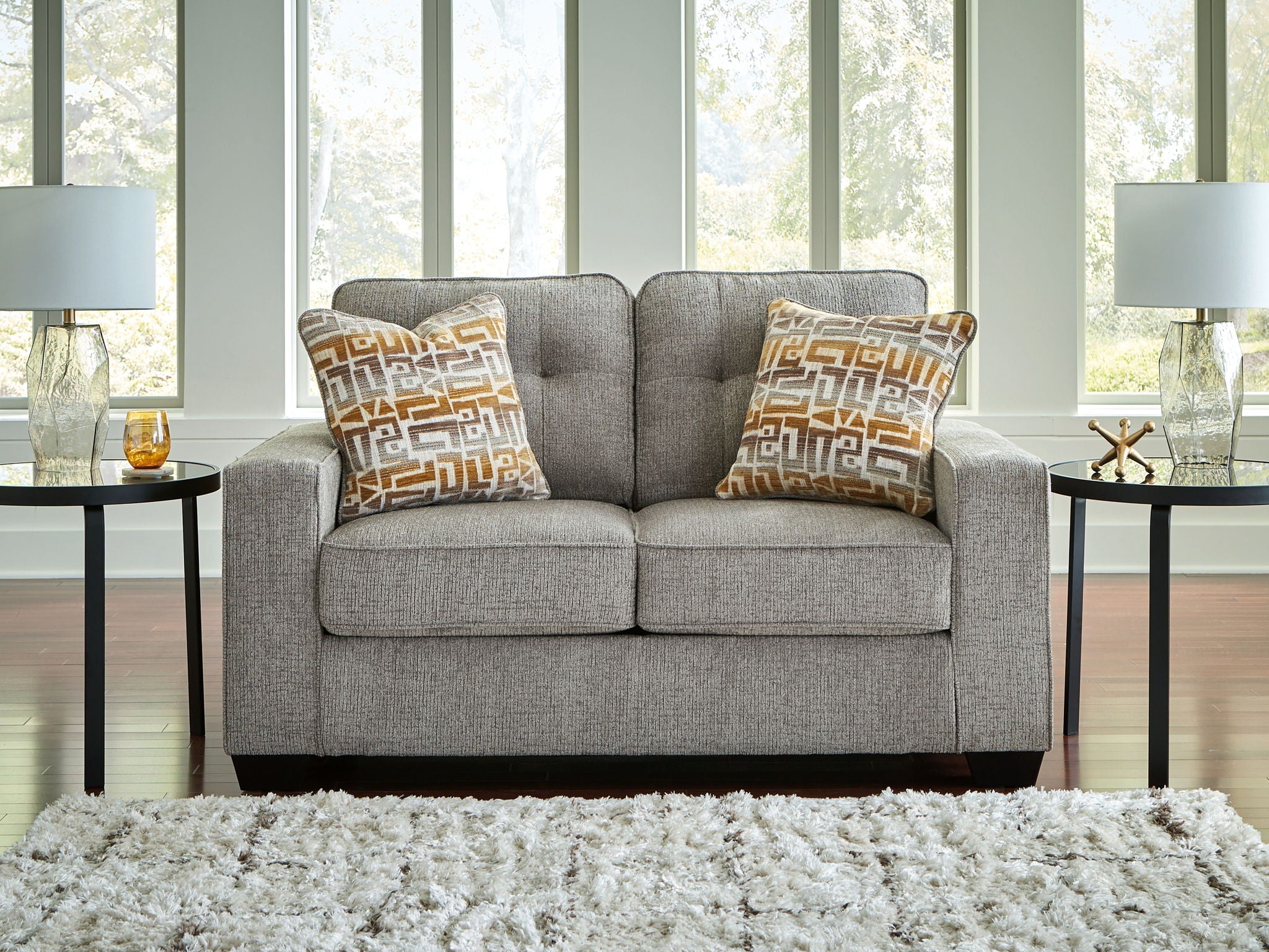 Gray loveseat with two square geometric-pattern throw pillows