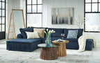 Navy modular sectional sofa with ribbed upholstery, chaise seat, and throw blanket