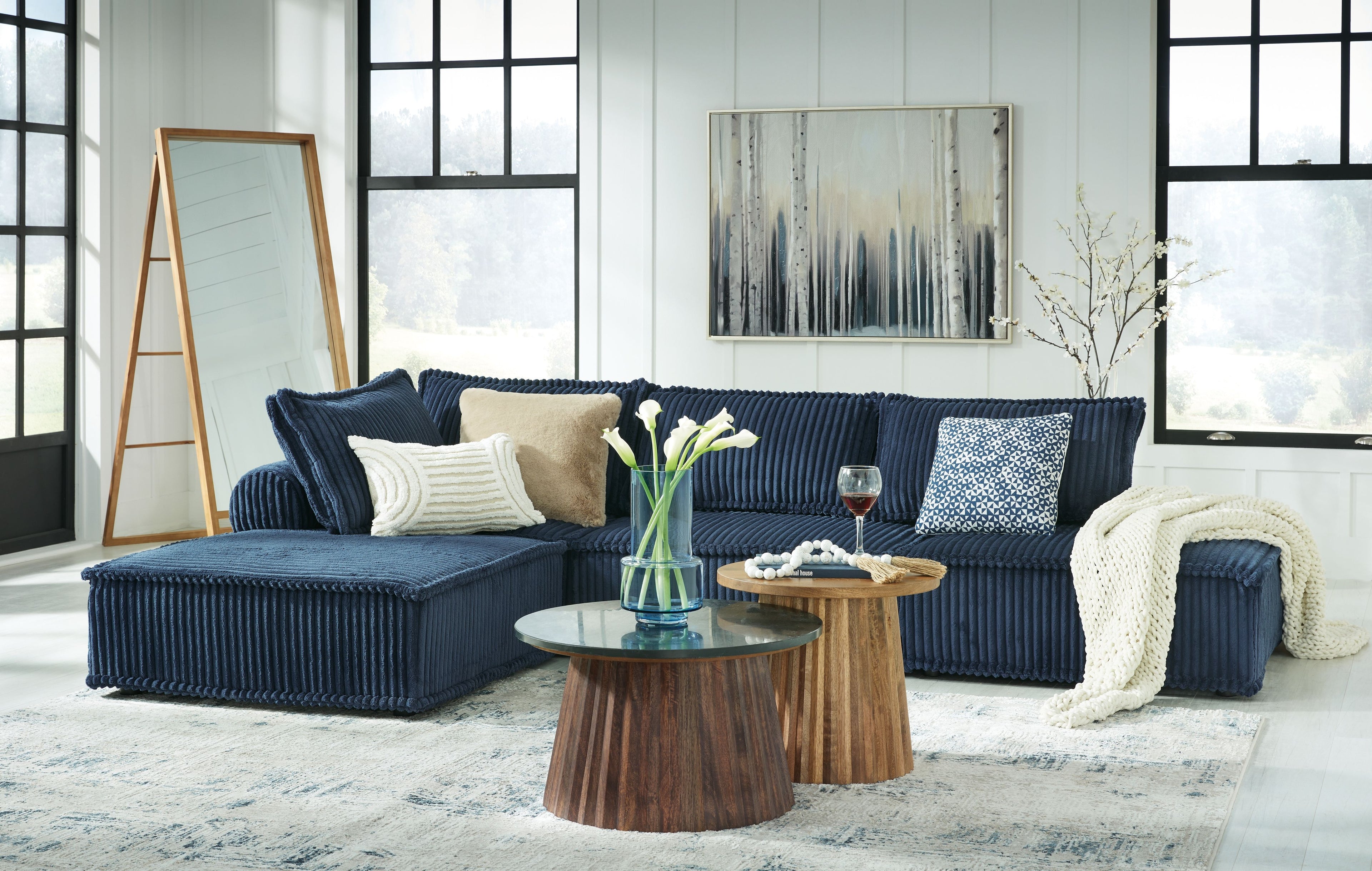 Navy modular sectional sofa with ribbed upholstery, chaise seat, and throw blanket