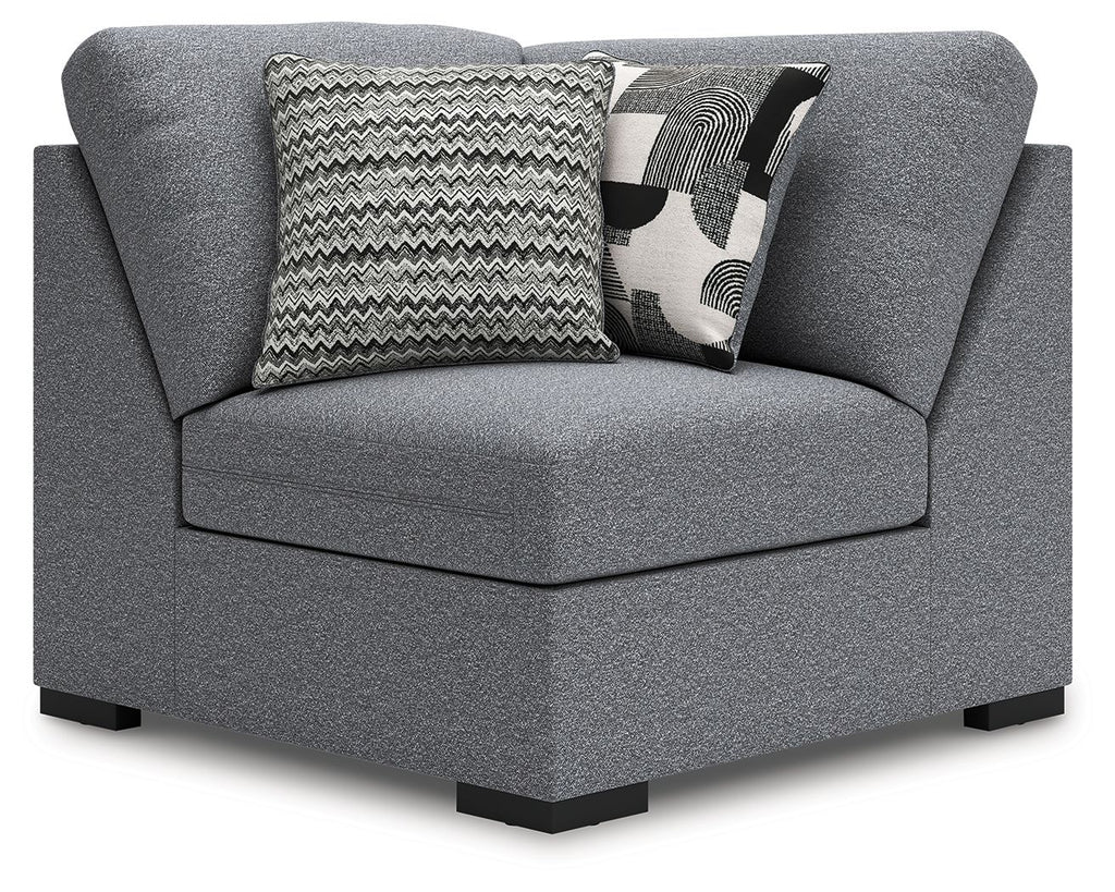 Gray upholstered wedge armchair with back cushions and zigzag throw pillow