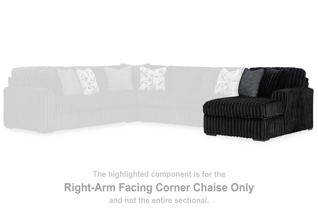 Black corner chaise section with rounded arm and thick seat cushions