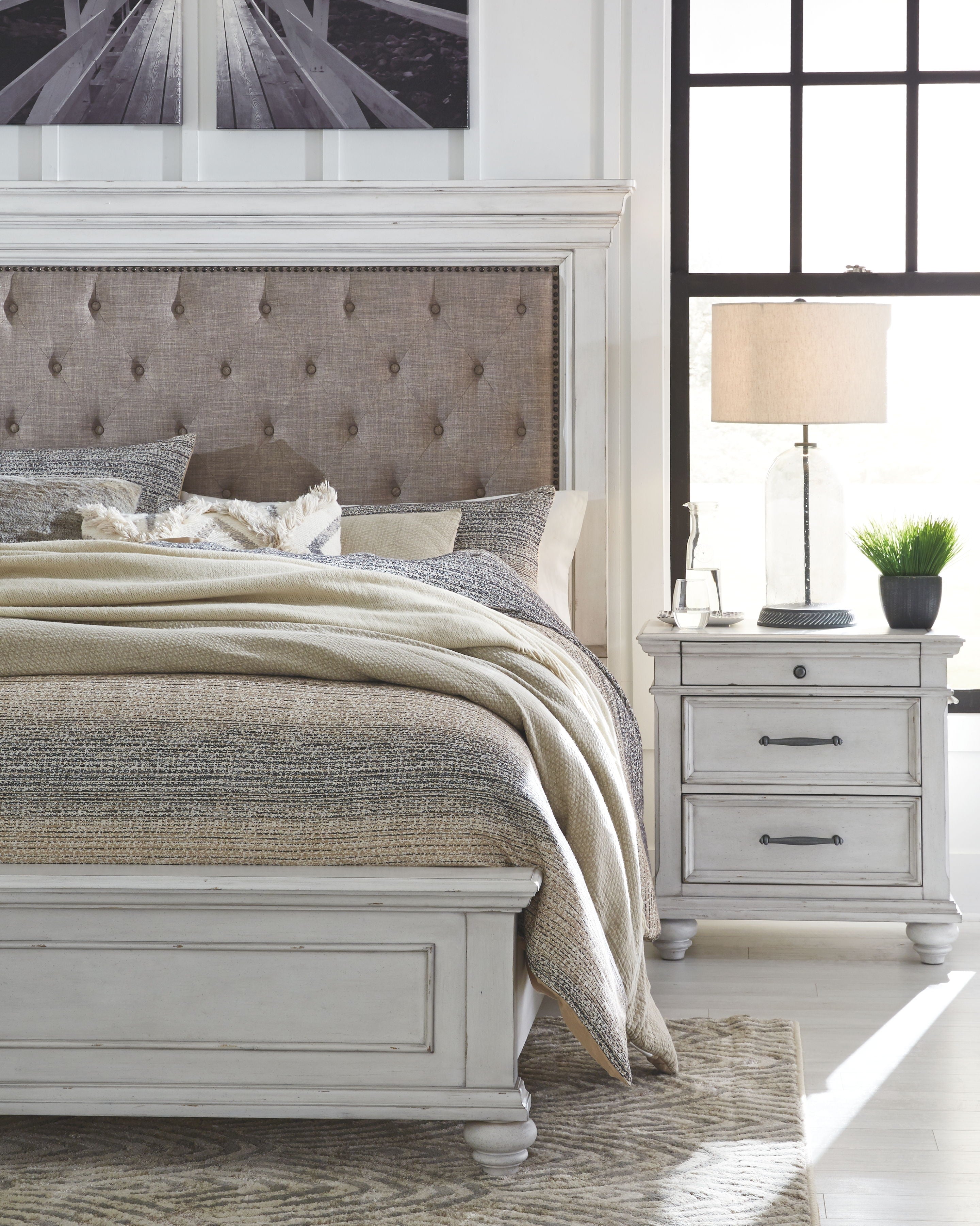 Upholstered bed frame with tufted headboard and a white nightstand with drawers