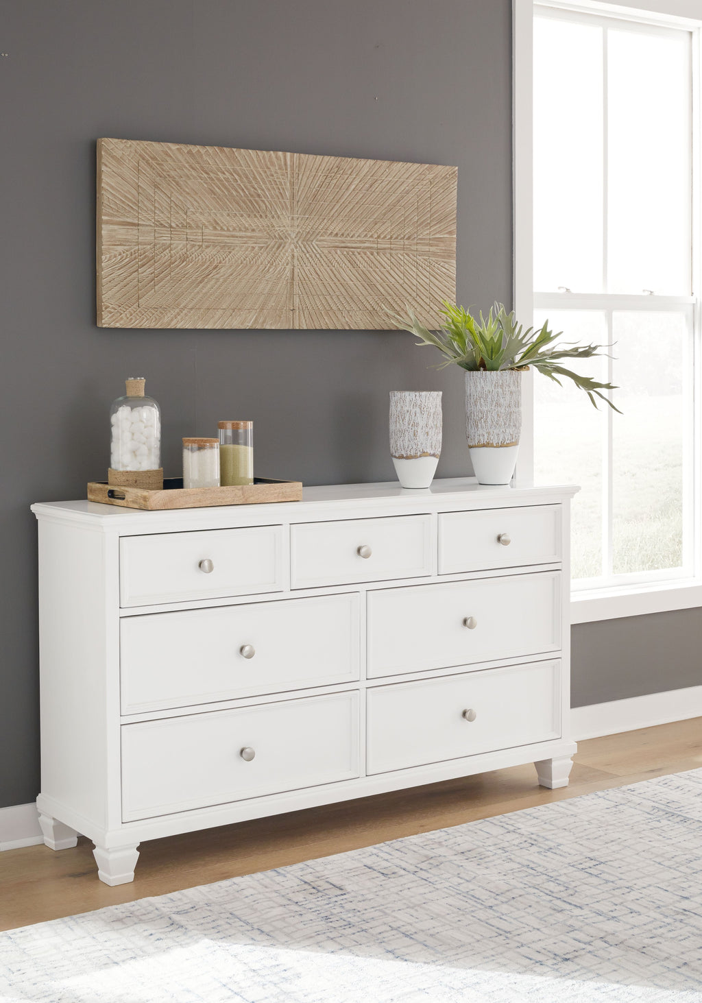 Fortman white dresser with eight drawers and round metal knobs, styled in a room