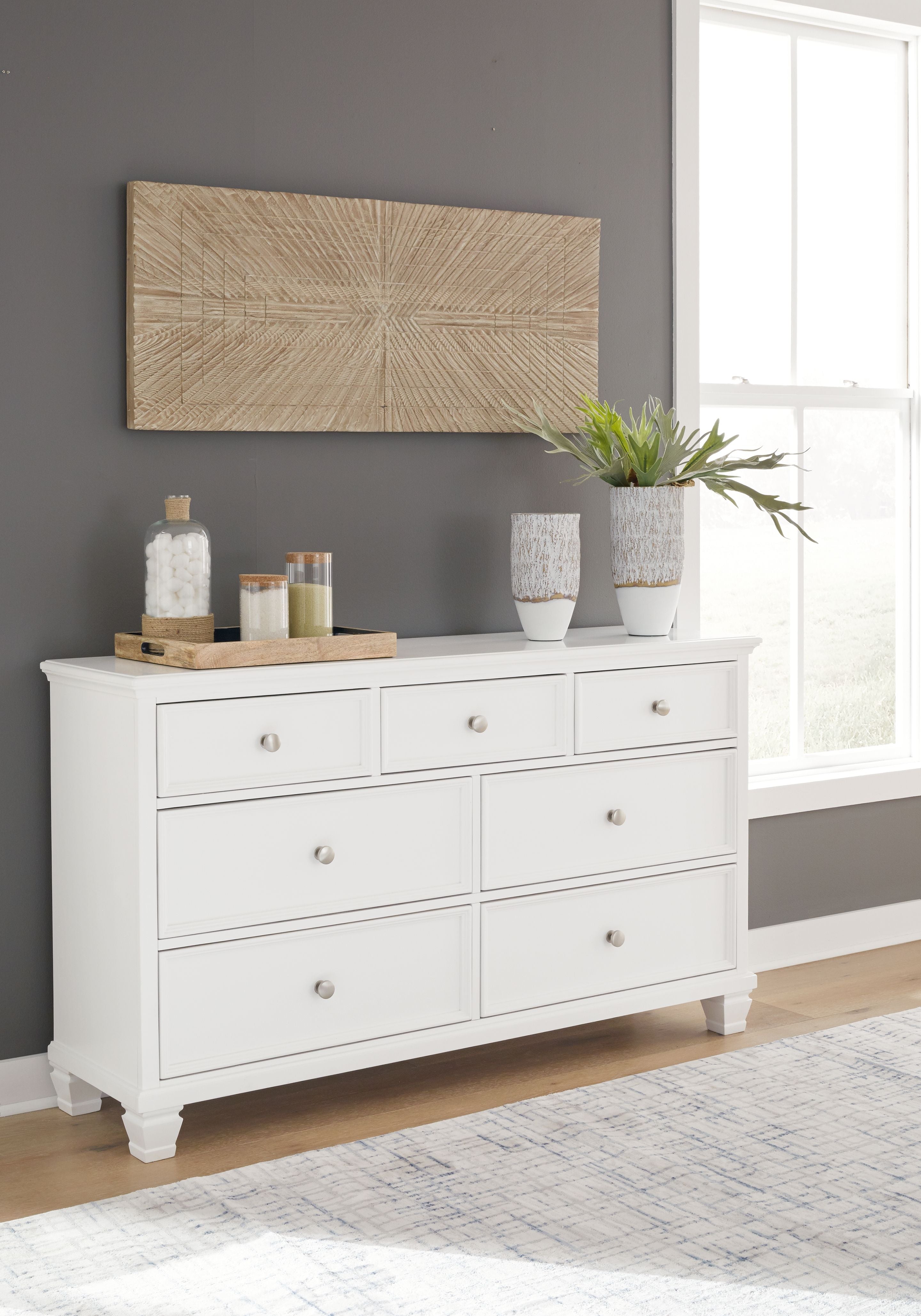 Fortman white dresser with eight drawers and round metal knobs, styled in a room