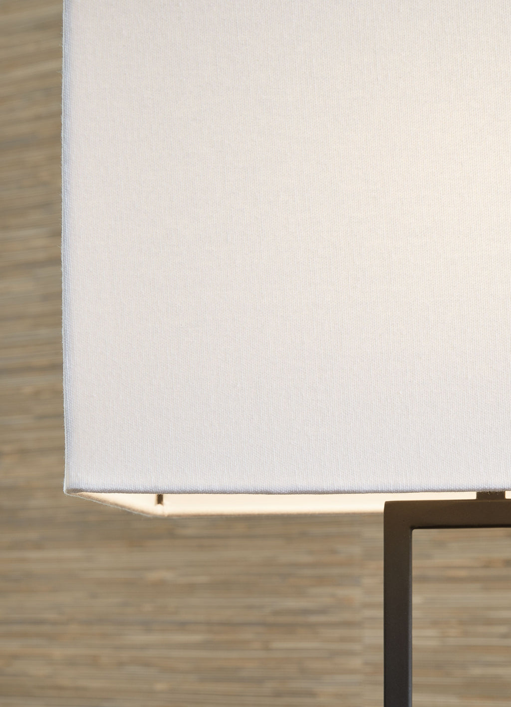 Metal table lamp with white fabric shade and black frame, partial close-up